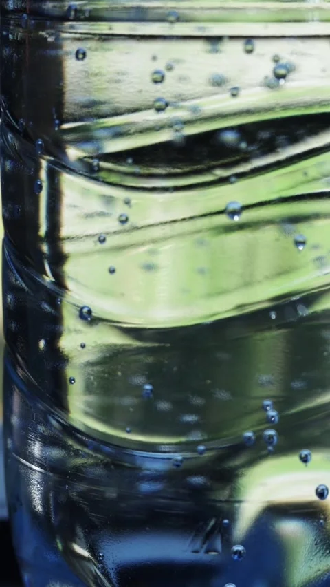 Close-up of clear water with tiny bubbles inside a textured plastic bottle Stock-Footage 343838075