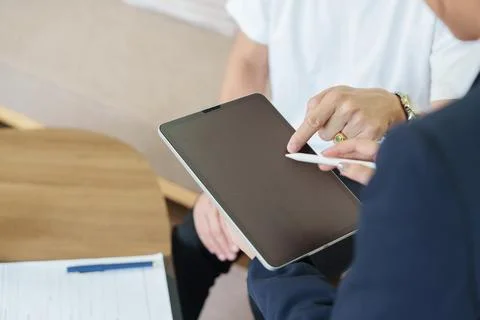 Close up of client and agent pointing at tablet screen during financial Stock Photos