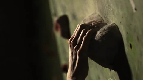 Close-up of a climber climbs on a stone wall indoors. The Sculpture. The hand is Stock Footage 85497657