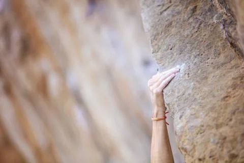 Close up climber's hand on ledge on cliff Stock Photos