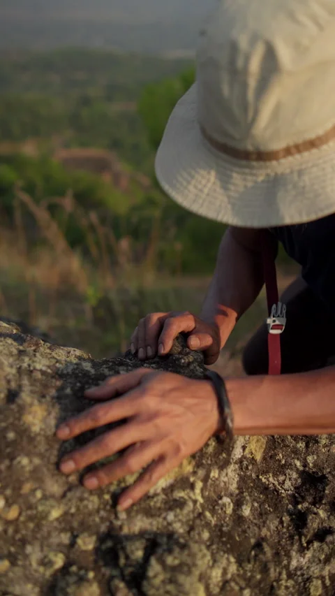 Close-up of a climber's hands gripping rugged rocks on a steep mountain surface Stock Footage 341767549
