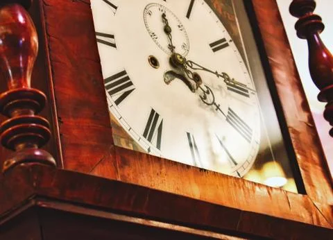 Close up of clock face on an antique grandfather clock with roman numerals Stock Photos