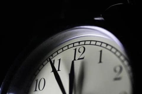 Close-Up of Clock Face Showing Time Near Midnight in Dark Background Stock Photos