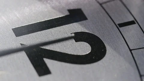 Close up of clock hands ticking past 12 o’clock on a clock face Stock Footage 74364148