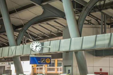Close up of clock at sky train terminal screen in the back and train is coming Stock Photos