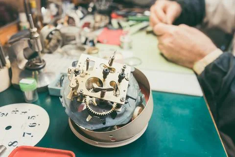 Close up on clockwork of clock to be repaired in watchmaker workshop Stock Photos