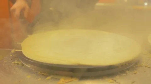 Close-up close-up of making crepes on plate with a lot of smoke Stock Footage 124495988