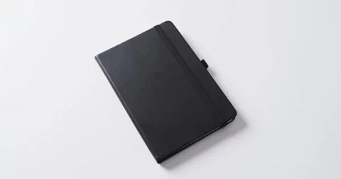 Close up of closed black notebook with copy space on white background in slow Stock Footage 331246201
