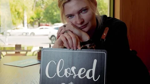 Close-up of a CLOSED sign in a cafe window, emphasizing business failure. Stock Footage 323175058