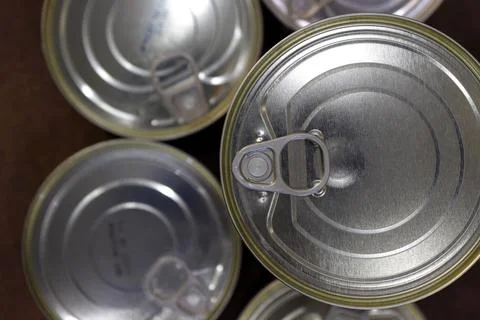 Close-up of closed tin cans with a key to open them Stock Photos