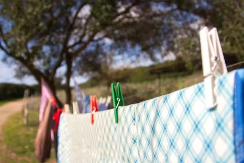 Close up of clothes with colorful bed sheets hanging on the wire with colore Stock Photos