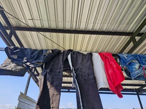 Close-up of clothes drying on a rooftop laundry line, under a clear sky wit.. Stock-Fotos