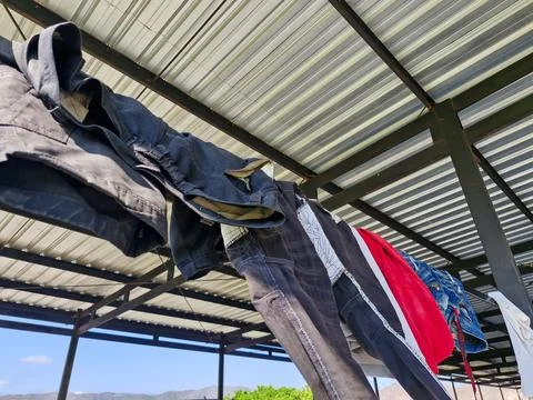 Close-up of clothes drying on a rooftop laundry line, under a clear sky wit.. Stock Photos