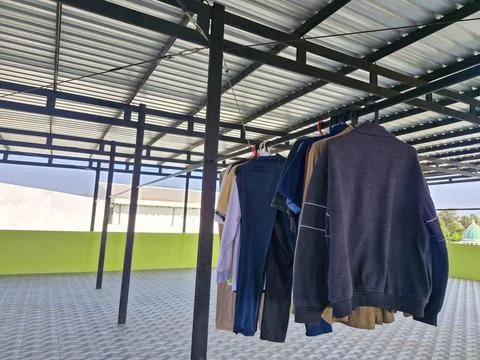Close-up of clothes drying on a rooftop laundry line, under a clear sky wit.. Stock Photos