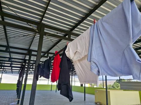 Close-up of clothes drying on a rooftop laundry line, under a clear sky wit.. Stock Photos