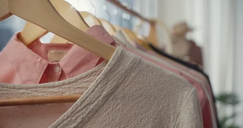 Close-up clothes hang on clothes rack in clothing store with sweet tone. Stock Footage 168524068