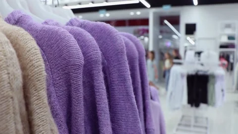 Close-up clothes hanger with colored sweaters in clothing store Stock-Footage 203909597