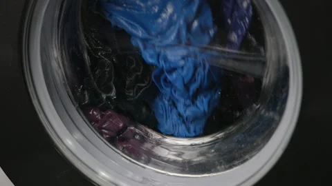 Close-up of clothes spinning inside washing machine drum Stock Footage 344926719