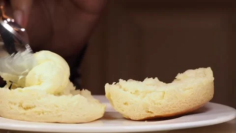 Close Up Of Clotted Cream Being Added to A Freshly Baked Scone,  UK Stock Footage 296038341