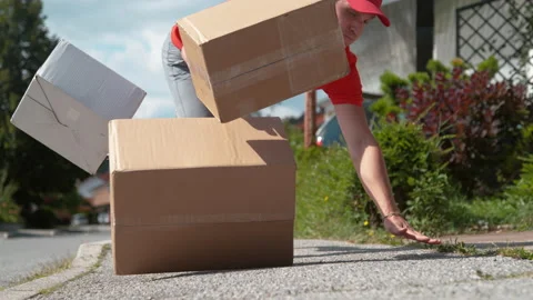 CLOSE UP: Clumsy delivery man falls to the ground and drops cardboard boxes Stock Footage 140038624
