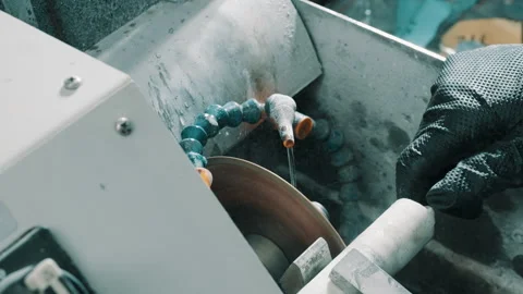 Close-Up of CNC Grinding Machine with Coolant and Operator's Gloved Hand Stock Footage 337927331