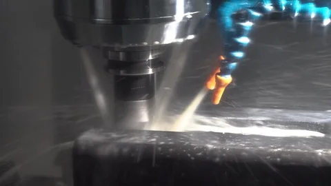 Close-up cnc machine milling a metal part with coolant Stock Footage 119985383