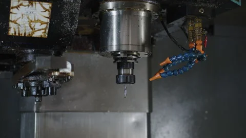 Close-up of a CNC machine in operation with cooling fluid spraying, Stock Footage 263017450