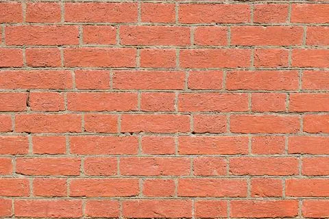 Close-up coarse texture with bright orange, uneven exposed brick Stock Photos