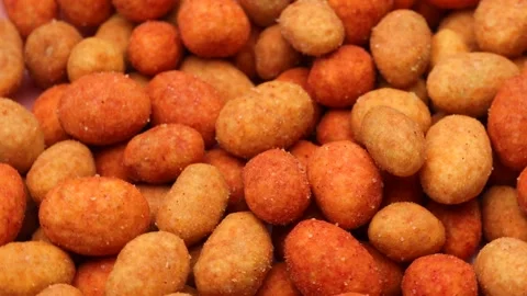 Close up of coated peanuts , rotation in circle. nuts in yellow glaze Stock Footage 237437769