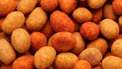 Close up of coated peanuts , rotation in circle. nuts in yellow glaze Stock Footage 241251183