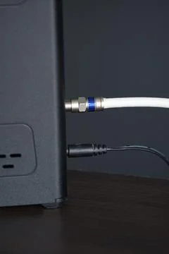 A close-up of a coaxial cable connected to an internet modem Stock Photos