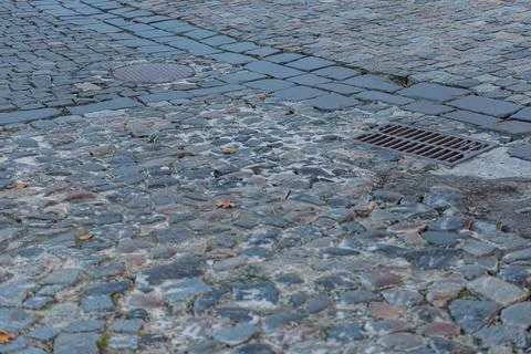 Close-up of cobblestone path, worn-down irregular stones in shades of gray .. Stock Photos