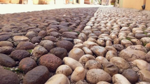 Close Up Of Cobblestone Pavement With Feet Of Pedestrians Passing By Stock Footage