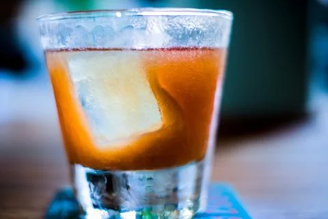 Close-up of cocktail with large rectangular ice cube in old-fashioned glass Foto stock