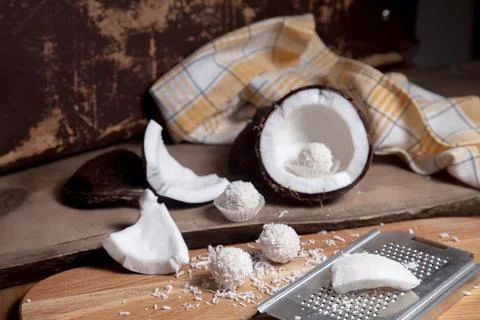 Close up of coconut with white pulp, grater with coconut chip and white candi Stock Photos