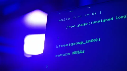 Close up of code on a screen in a server room with flashing red lights 스톡 동영상 287371123