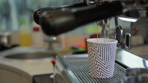 Close up of coffe is being poured to the cup from machine and taken away by male Stock Footage 92320313