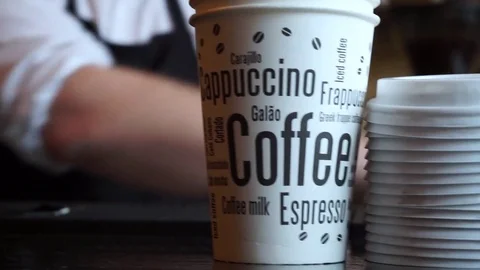 Close up of coffee 2 go cups on counter in front of a barista Video stock 85370130