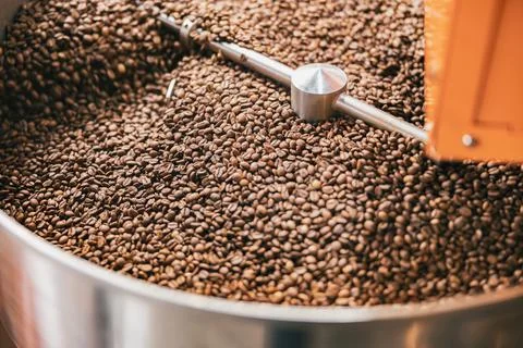 Close up of coffee beans in coffee roasting machine in a small manufacturing Stock Photos