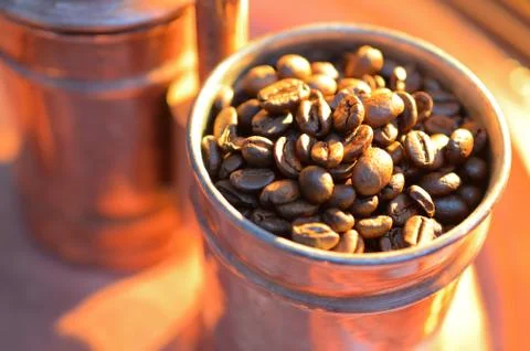 Close up coffee beans  to in a copper container on a dark background Stock Photos