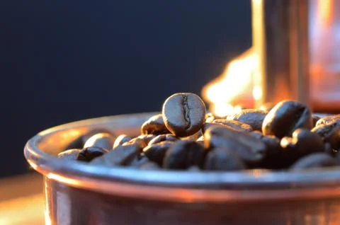 Close up coffee beans  to in a copper container on a dark background Stock Photos