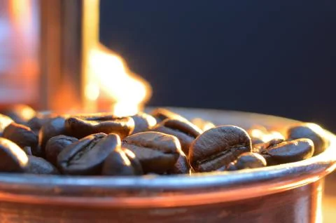 Close up coffee beans to in a copper container on a dark background Stock Photos