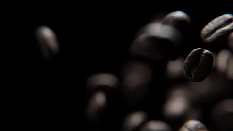 Close up of Coffee beans falling against a black background Stock Footage 253626320