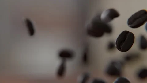 Close up of Coffee beans falling on and bouncing off of the wooden table Stock Footage 253626474