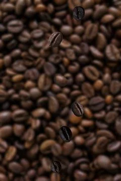 Close-up of coffee beans falling onto a stack of coffee beans Foto stock