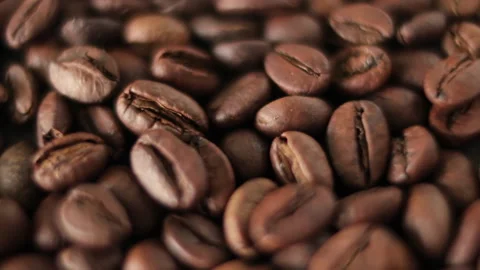 Close-up coffee beans rotate. Roasted coffee beans are spinning in a circle. Stock Footage 308800314