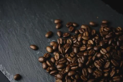Close up Coffee beans on a slate texture. Isolated dark background. Celebrate Stock Photos