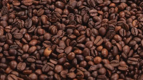 Close-up of coffee beans slowly spinning, with coffee beans falling from above. Stock Footage 311153029