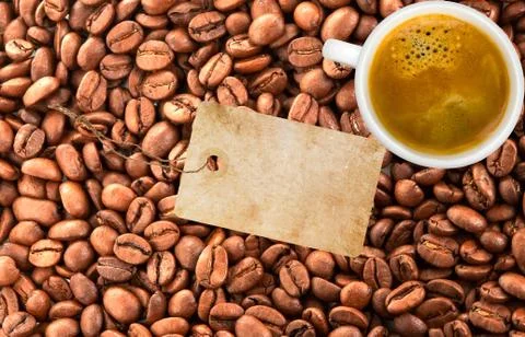 Close-up of coffee beans, white cup of coffee and blank tag Foto stock