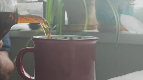 Close up of coffee being poured from a glass coffee pot into a red ceramic mug Stock Footage 346539967